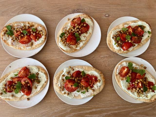 Platbrood met kruidenyoghurt, geroosterde kikkererwten en tomaat